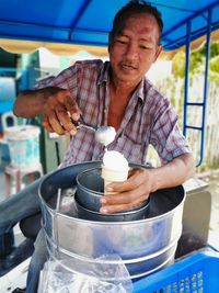 Vendor making ice cream cone at market