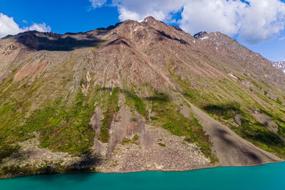 Scenic view of mountain range against cloudy sky