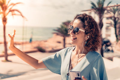 Portrait of woman wearing sunglasses at beach