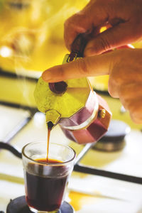 Close-up of hand pouring drink in glass