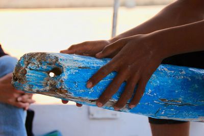 Close-up of hand holding blue wood