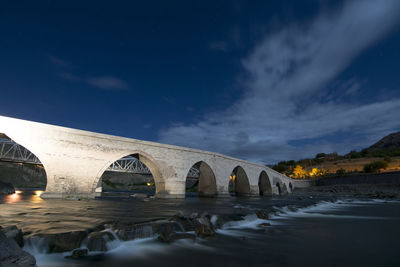 Low angle view of bridge over river against sky