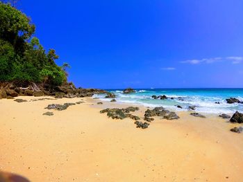 Scenic view of beach against blue sky