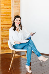 Portrait of young woman sitting on chair