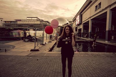 Woman standing on road with buildings in background