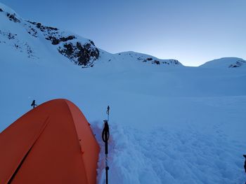 People on snowcapped mountain against sky