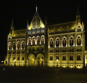 Illuminated building against sky at night