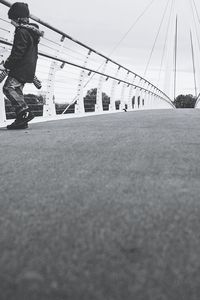 Man on bridge against sky