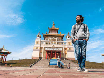 Full length of man standing outside building against sky