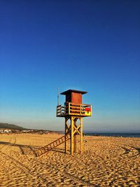 Low angle view of lookout tower on beach against sky