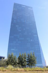 Low angle view of modern building against blue sky