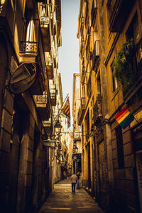 People walking on narrow street amidst buildings in city