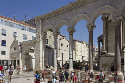 People on street against buildings in city