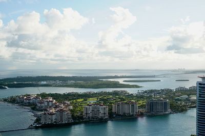 High angle view of city by sea against sky