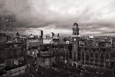 Buildings in city against cloudy sky