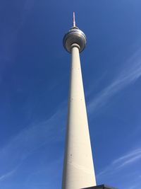 Low angle view of communications tower against blue sky