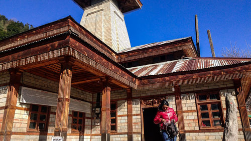 Low angle view of woman standing against building