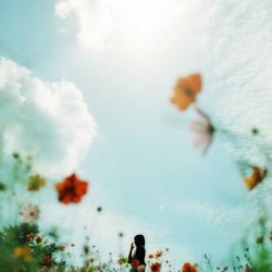 Low angle view of woman on field against cloudy sky