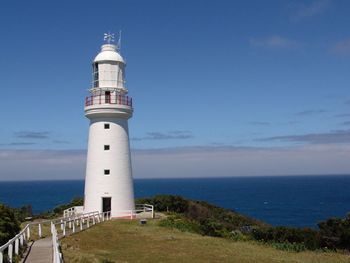 Lighthouse by sea against sky