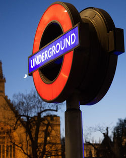 Close-up of road sign against blue sky