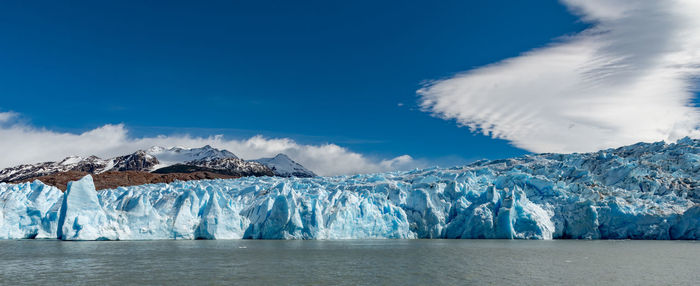 Panoramic view of sea and snowcapped mountains against sky