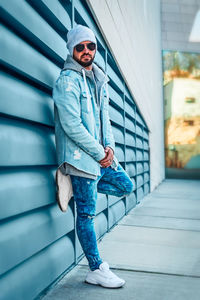 Portrait of man standing against wall