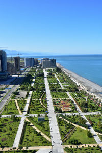 Aerial view of buildings and sea against clear blue sky