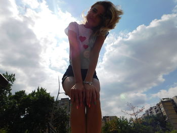 Low angle view of woman standing against sky