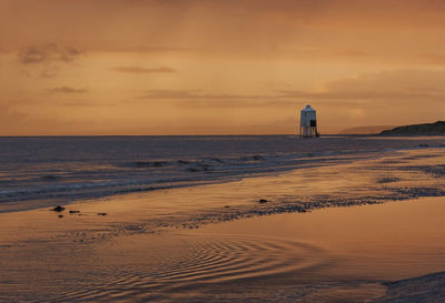 Scenic view of beach against sky during sunset