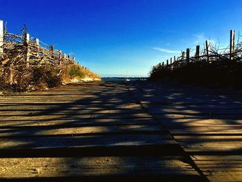 Empty road against clear blue sky