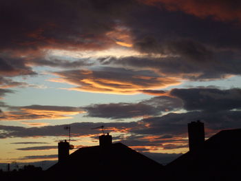 Silhouette roof against sky during sunset