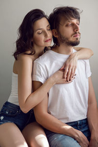 Guy and a girl on a white background in the studio are happy with life