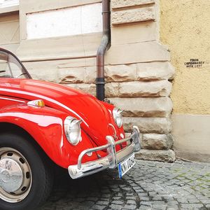 Red vintage car on brick wall