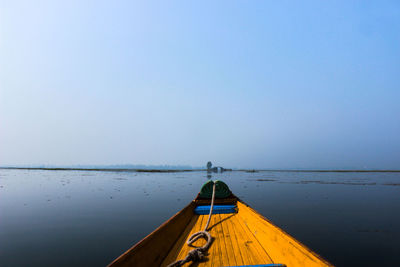 Boat sailing on sea against clear blue sky