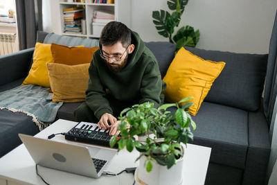 Woman using laptop on sofa at home