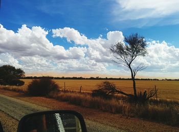 Scenic view of field against cloudy sky