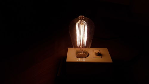 Close-up of illuminated lamp against black background