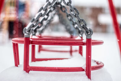 Close-up of snow covered empty seat