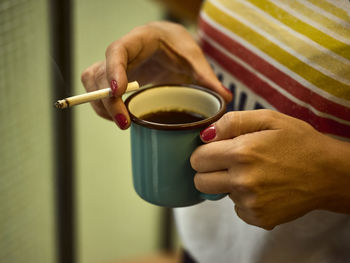 Midsection of woman holding coffee cup