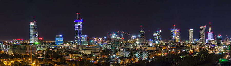 Panoramic view of illuminated buildings against sky at night