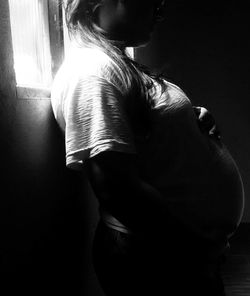 Rear view of senior woman standing against wall