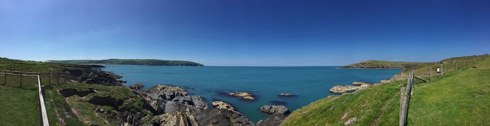 Panoramic view of sea against clear blue sky