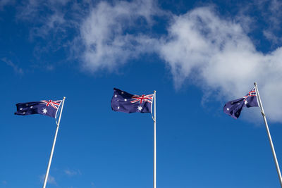 Low angle view of flag flags against sky