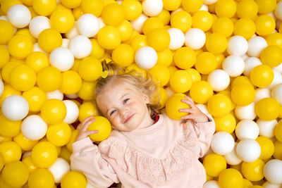 Funny cute little caucaisian blonde baby girl,toddler, smiling happy kid having fun in ball pool