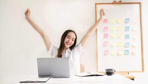 Midsection of woman using laptop at office