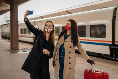 Full length of woman photographing with mobile phone