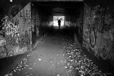 Rear view of man walking in tunnel
