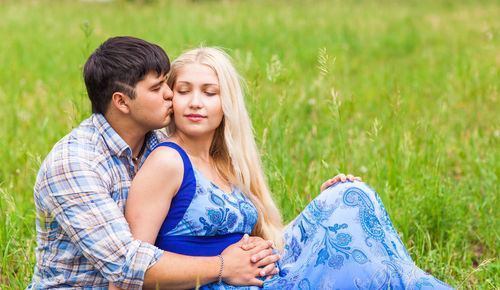 Young couple kissing on field