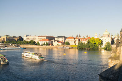 Boats in river with buildings in background