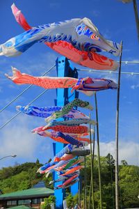 Low angle view of flags hanging on pole against sky